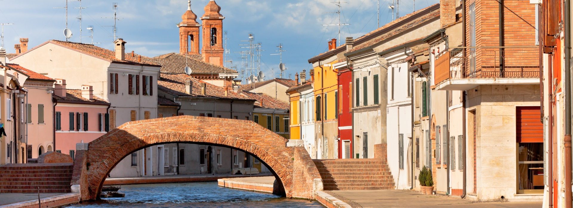 Comacchio (Ferrara, Emilia Romagna, Italy). Canal with bridge and colorful houses.