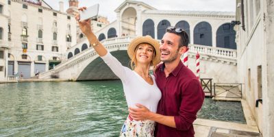 Beatiful young couple having fun while visiting Venice - Tourists travelling in Italy and sightseeing the most relevant landmarks of Venezia - Concepts about lifestyle, travel, tourism