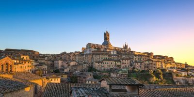 Siena sunset panoramic skyline. Mangia tower and Cathedral Duomo landmark. Tuscany, Italy.